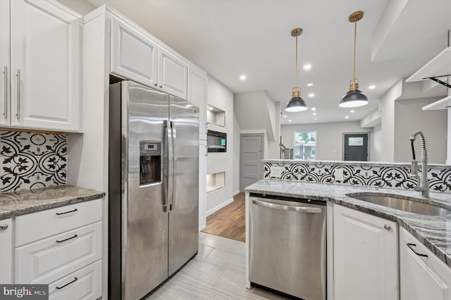 1408 N Redfield St, Philadelphia, PA 19151 - kitchen with appliances with stainless steel finishes, white cabinetry, tasteful backsplash, light stone countertops, and decorative light fixtures