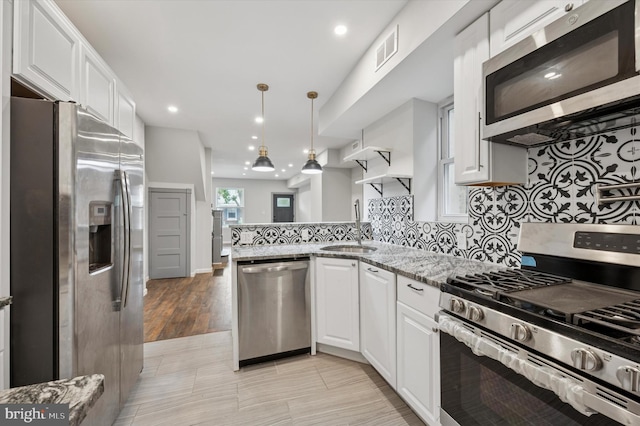 1408 N Redfield St, Philadelphia, PA 19151 - kitchen with stainless steel appliances, a peninsula, white cabinets, light stone countertops, and recessed lighting