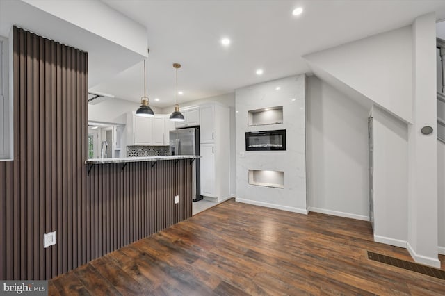 1408 N Redfield St, Philadelphia, PA 19151 - kitchen featuring freestanding refrigerator, white cabinetry, a peninsula, dark wood-type flooring, and a kitchen breakfast bar