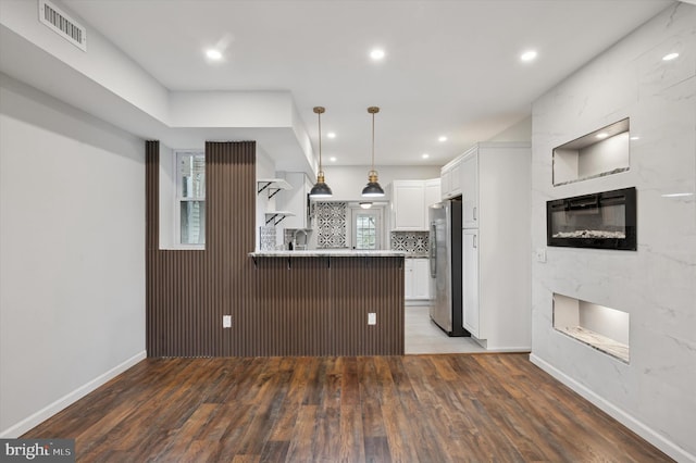 1408 N Redfield St, Philadelphia, PA 19151 - kitchen featuring freestanding refrigerator, a high end fireplace, a peninsula, wood finished floors, and white cabinetry