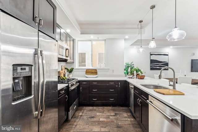 1518 Frankford Ave Unit 1, Philadelphia, PA 19125 - kitchen featuring appliances with stainless steel finishes, dark wood-style floors, light countertops, a peninsula, and decorative light fixtures