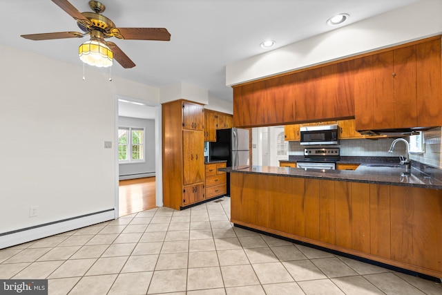 10833 Hunting Ln, Columbia, MD 21044 - kitchen featuring stainless steel appliances, brown cabinetry, a baseboard radiator, a peninsula, and backsplash