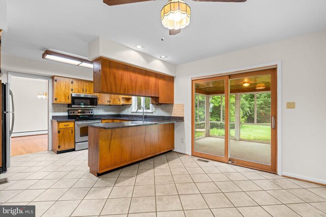 10833 Hunting Ln, Columbia, MD 21044 - kitchen with stainless steel appliances, a peninsula, a baseboard radiator, brown cabinets, and dark countertops