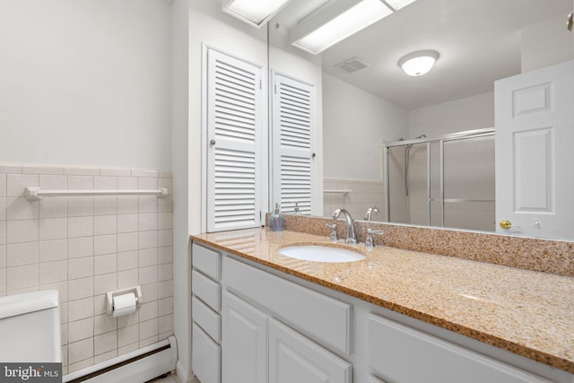 10833 Hunting Ln, Columbia, MD 21044 - full bath with vanity, a baseboard radiator, a shower stall, tile walls, and a wainscoted wall