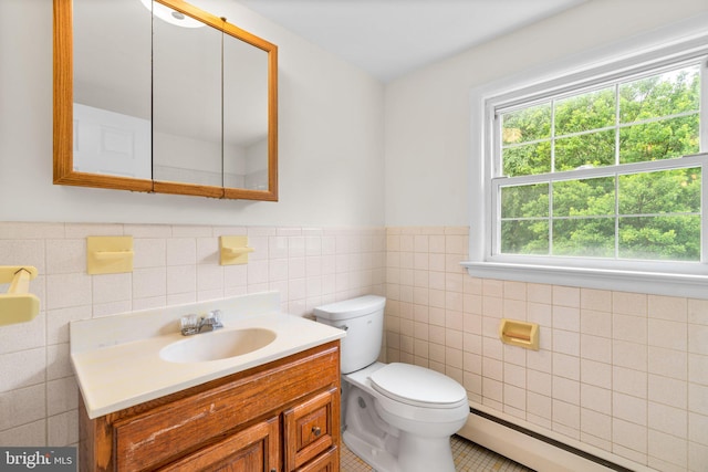 10833 Hunting Ln, Columbia, MD 21044 - bathroom featuring baseboard heating, tile walls, vanity, a wainscoted wall, and tile patterned flooring