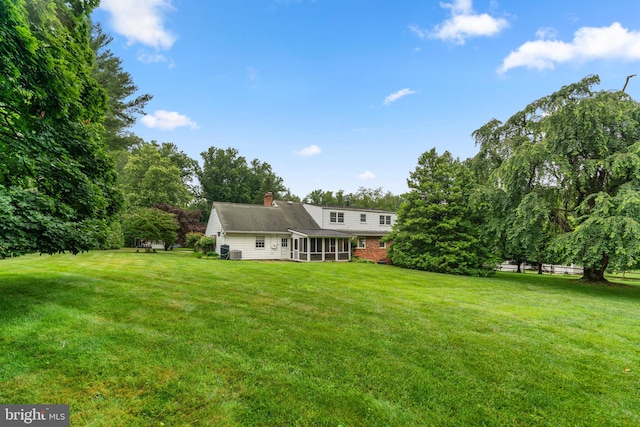 10833 Hunting Ln, Columbia, MD 21044 - rear view of house featuring a sunroom, a yard, and a chimney