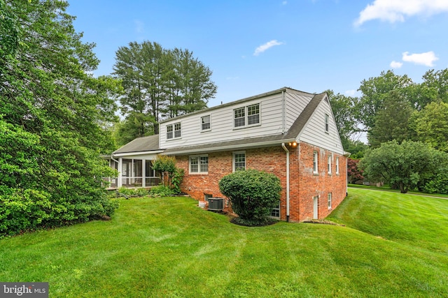 10833 Hunting Ln, Columbia, MD 21044 - back of house featuring brick siding, a sunroom, and a yard