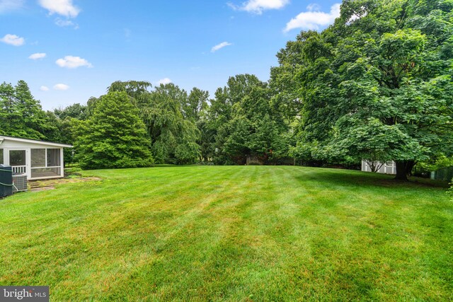 10833 Hunting Ln, Columbia, MD 21044 - view of grassy yard featuring a sunroom and a forest view