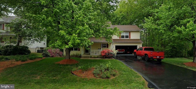 4303 Wickham Ct, Fredericksburg, VA 22408 - view of property hidden behind natural elements featuring asphalt driveway, a garage, a front yard, and covered porch