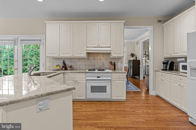 14 Leapson Ln, Doylestown, PA 18901 - kitchen featuring white appliances, under cabinet range hood, white cabinets, backsplash, and light wood-style floors