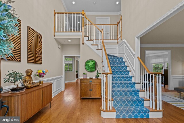 14 Leapson Ln, Doylestown, PA 18901 - stairs featuring wood finished floors, a towering ceiling, a wainscoted wall, crown molding, and a decorative wall