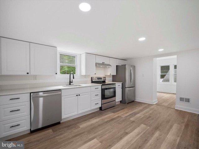 667 Thompson Rd, Needmore, PA 17238 - kitchen featuring appliances with stainless steel finishes, under cabinet range hood, recessed lighting, healthy amount of natural light, and white cabinets