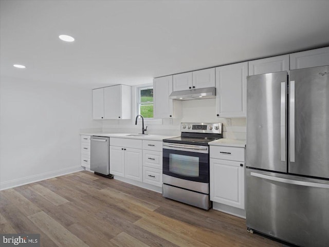 667 Thompson Rd, Needmore, PA 17238 - kitchen with stainless steel appliances, under cabinet range hood, light countertops, white cabinets, and recessed lighting