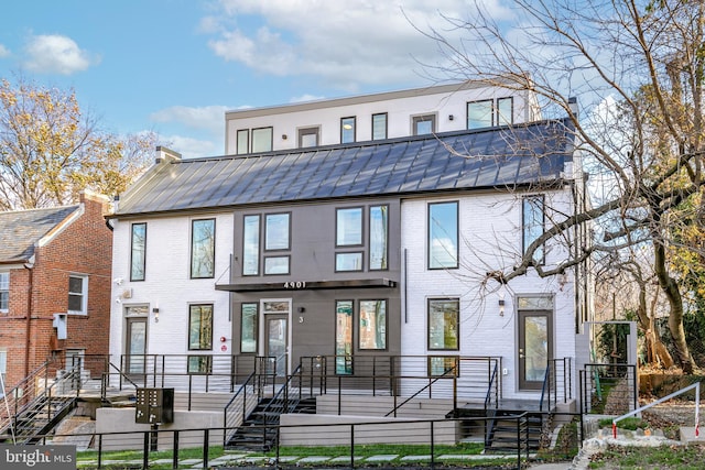 4901 1st St NW Unit 5, Washington, DC 20011 - view of property featuring a fenced front yard, brick siding, and a metal roof