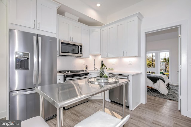 4901 1st St NW Unit 5, Washington, DC 20011 - kitchen with appliances with stainless steel finishes, light countertops, light wood-style flooring, white cabinetry, and recessed lighting