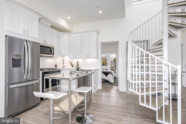 4901 1st St NW Unit 5, Washington, DC 20011 - kitchen with appliances with stainless steel finishes, white cabinets, light wood finished floors, recessed lighting, and light countertops