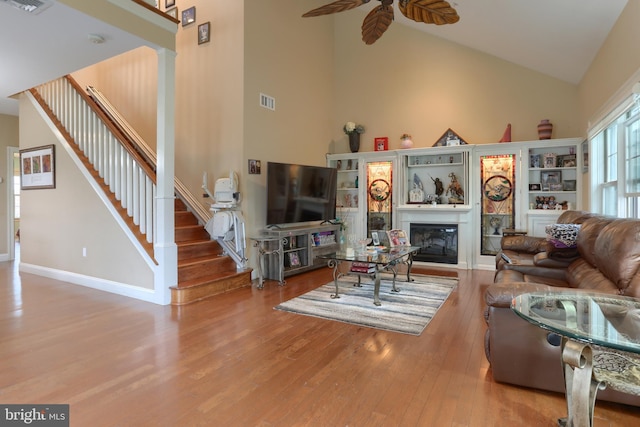 162 High Pointe Dr, Hummelstown, PA 17036 - living area with high vaulted ceiling, a ceiling fan, hardwood / wood-style flooring, stairs, and a glass covered fireplace