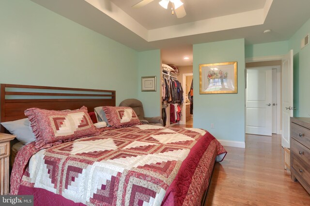 162 High Pointe Dr, Hummelstown, PA 17036 - bedroom featuring wood finished floors, a raised ceiling, a spacious closet, a closet, and ceiling fan