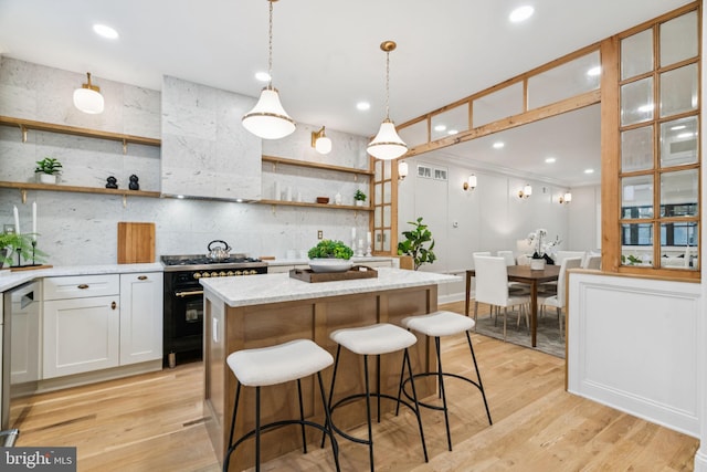 1310 E Passyunk Ave, Philadelphia, PA 19147 - kitchen featuring high end black range oven, open shelves, a center island, light stone counters, and recessed lighting