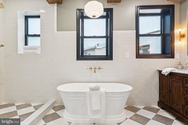 1310 E Passyunk Ave, Philadelphia, PA 19147 - bathroom featuring tile walls, vanity, a freestanding tub, and a wainscoted wall
