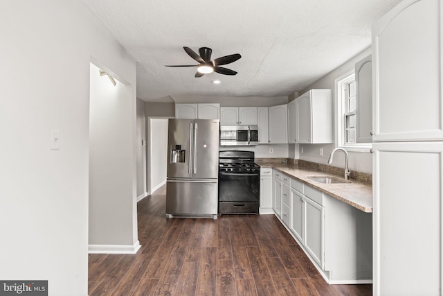 16 Richardson Ave, Linwood, PA 19061 - kitchen featuring appliances with stainless steel finishes, a ceiling fan, white cabinets, dark wood finished floors, and light stone counters