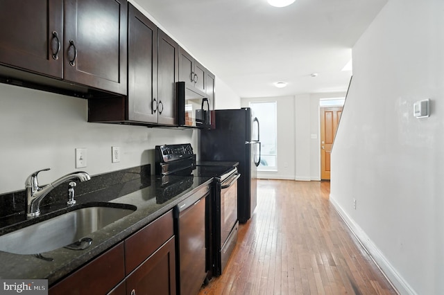 437 Pitman Pl, Baltimore, MD 21202 - kitchen featuring electric range, light wood-type flooring, dishwashing machine, dark stone countertops, and dark brown cabinetry