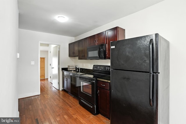 437 Pitman Pl, Baltimore, MD 21202 - kitchen featuring black appliances, wood-type flooring, and dark brown cabinetry