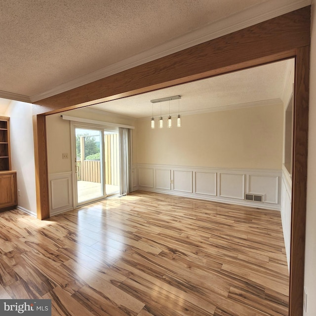 184 Steven Ln, Wilmington, DE 19808 - empty room with ornamental molding, a textured ceiling, light wood-style flooring, a decorative wall, and a wainscoted wall
