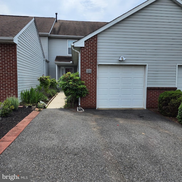 184 Steven Ln, Wilmington, DE 19808 - view of side of property featuring brick siding, asphalt driveway, a garage, and roof with shingles