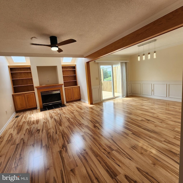 184 Steven Ln, Wilmington, DE 19808 - unfurnished living room with a ceiling fan, a textured ceiling, light wood-type flooring, a fireplace with flush hearth, and built in features