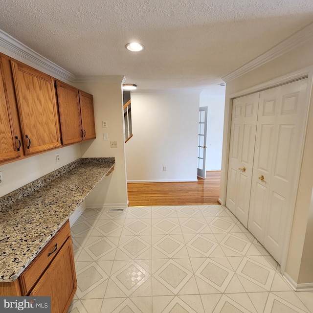 184 Steven Ln, Wilmington, DE 19808 - kitchen featuring brown cabinets, ornamental molding, a textured ceiling, recessed lighting, and light stone countertops