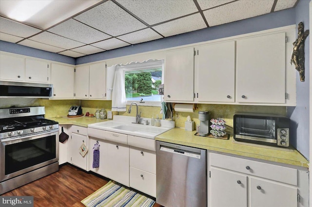 325 Summit Ave, Reading, PA 19607 - kitchen featuring appliances with stainless steel finishes, a paneled ceiling, light countertops, white cabinetry, and dark wood-style floors
