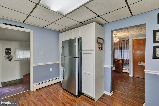 325 Summit Ave, Reading, PA 19607 - kitchen featuring freestanding refrigerator, a baseboard radiator, white cabinetry, wood finished floors, and a drop ceiling