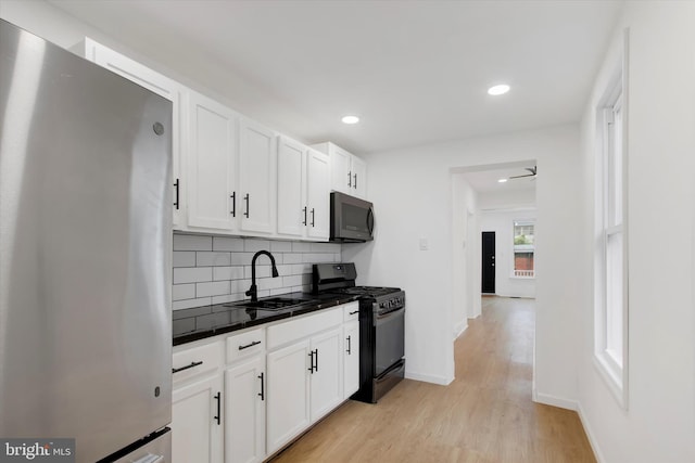 749 Church St, Reading, PA 19601 - kitchen featuring freestanding refrigerator, range with gas stovetop, dark countertops, tasteful backsplash, and white cabinets
