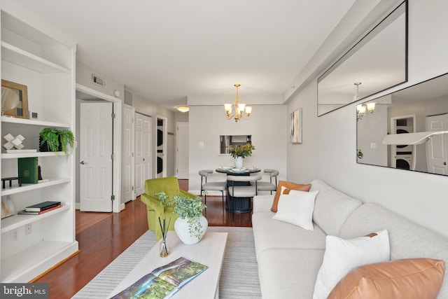 3401 38th St NW Unit 411, Washington, DC 20016 - living room with stacked washer and clothes dryer, a chandelier, and wood finished floors