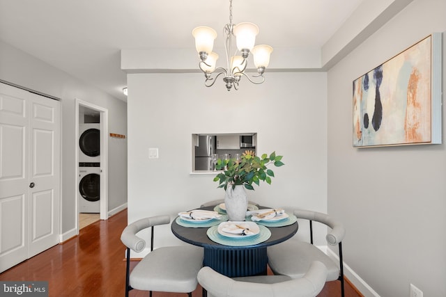 3401 38th St NW Unit 411, Washington, DC 20016 - dining area featuring stacked washer and clothes dryer, a chandelier, and wood finished floors