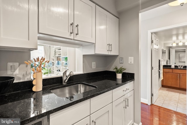 3401 38th St NW Unit 411, Washington, DC 20016 - kitchen featuring white cabinetry, dark stone counters, and light wood-type flooring