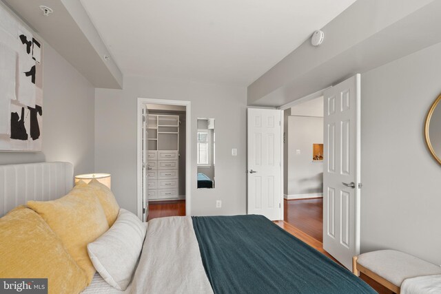 3401 38th St NW Unit 411, Washington, DC 20016 - bedroom with wood finished floors, a walk in closet, and a closet