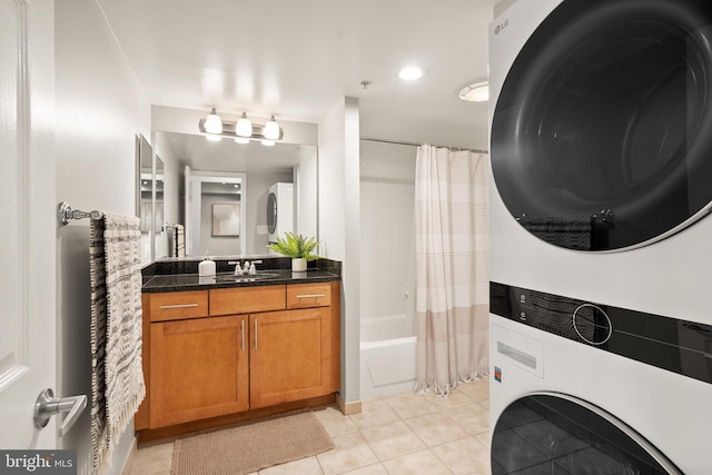 3401 38th St NW Unit 411, Washington, DC 20016 - bathroom featuring estacked washer and dryer, tile patterned flooring, vanity, and shower / bath combo with shower curtain
