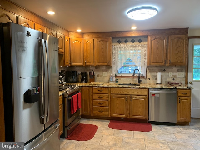 554 Locust St, Bristol, PA 19007 - kitchen with appliances with stainless steel finishes, backsplash, light stone countertops, brown cabinetry, and recessed lighting