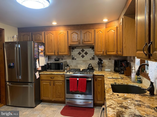 554 Locust St, Bristol, PA 19007 - kitchen featuring stainless steel appliances, backsplash, light stone countertops, and brown cabinets