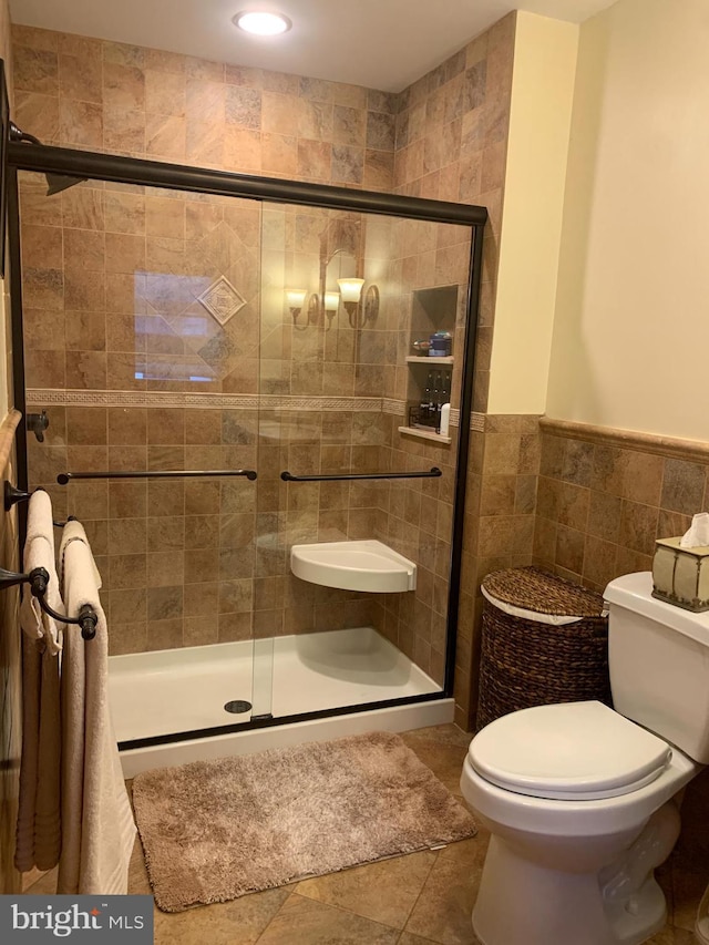554 Locust St, Bristol, PA 19007 - bathroom with a stall shower, tile walls, wainscoting, tile patterned floors, and recessed lighting