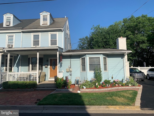554 Locust St, Bristol, PA 19007 - view of front of home with covered porch, cooling unit, and a chimney