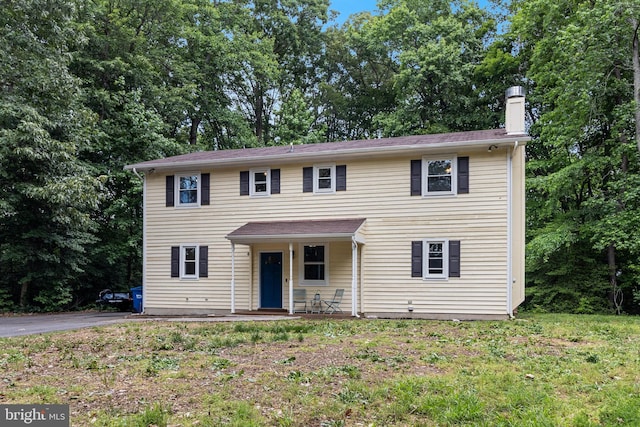 10560 S Faulkner Rd, Faulkner, MD 20632 - colonial-style house featuring a chimney, a porch, and view of wooded area