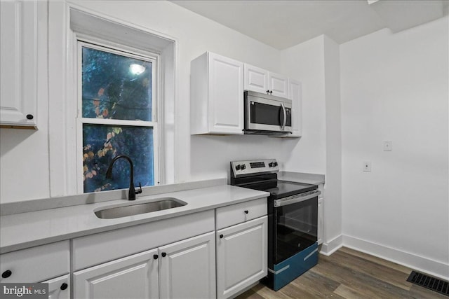 18 Belview Ave, Hagerstown, MD 21742 - kitchen with stainless steel appliances, white cabinetry, dark wood finished floors, and light countertops