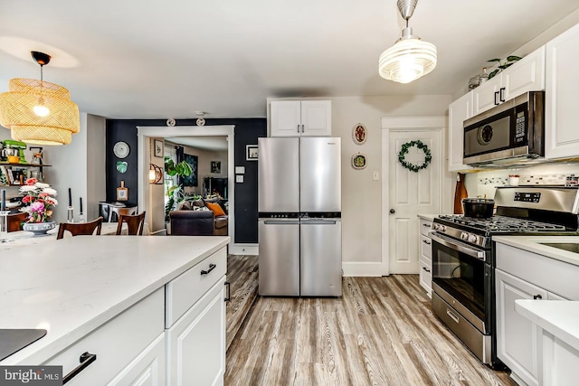 15 Willowbrook Ave, Lansdowne, PA 19050 - kitchen featuring appliances with stainless steel finishes, light wood-style floors, white cabinetry, and pendant lighting