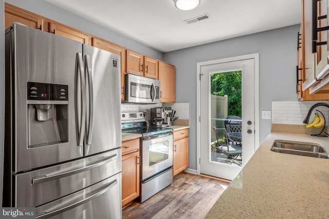 121 Westpoint Dr, Carlisle, PA 17013 - kitchen with appliances with stainless steel finishes, tasteful backsplash, light wood-style floors, and light brown cabinets