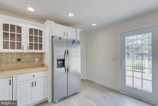 24750 Peterkins Rd, Georgetown, DE 19947 - kitchen with stainless steel fridge with ice dispenser, tasteful backsplash, glass insert cabinets, white cabinets, and light wood finished floors