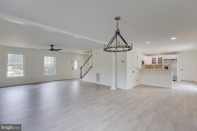 24750 Peterkins Rd, Georgetown, DE 19947 - unfurnished living room with a chandelier, light wood-type flooring, stairs, ceiling fan, and recessed lighting