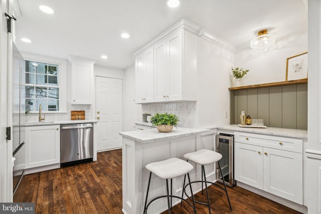 1935 S Hemberger St, Philadelphia, PA 19145 - kitchen with stainless steel dishwasher, beverage cooler, white cabinets, tasteful backsplash, and dark wood-type flooring